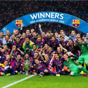 El equipo del FC Barcelona posando con el trofeo de la Liga de Campeones de la UEFA, celebrando su victoria tras una temporada exitosa.